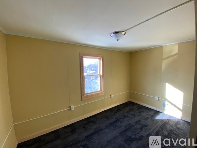 A room with a window and a black floor.