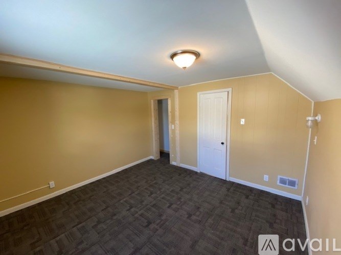 A room with a carpeted floor and a white door.