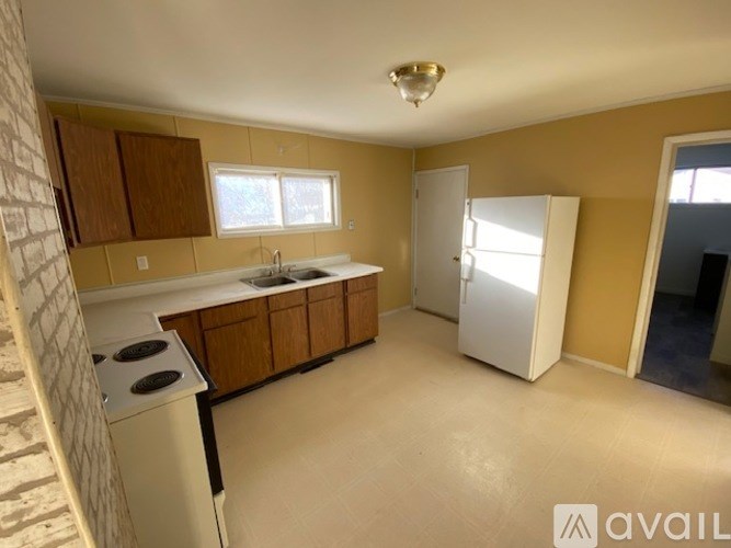 A kitchen with a white stove top oven and a white refrigerator.