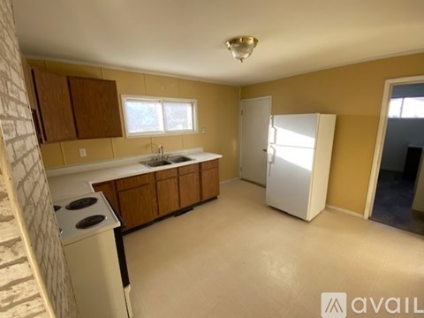 A kitchen with a white stove top oven and a white refrigerator.