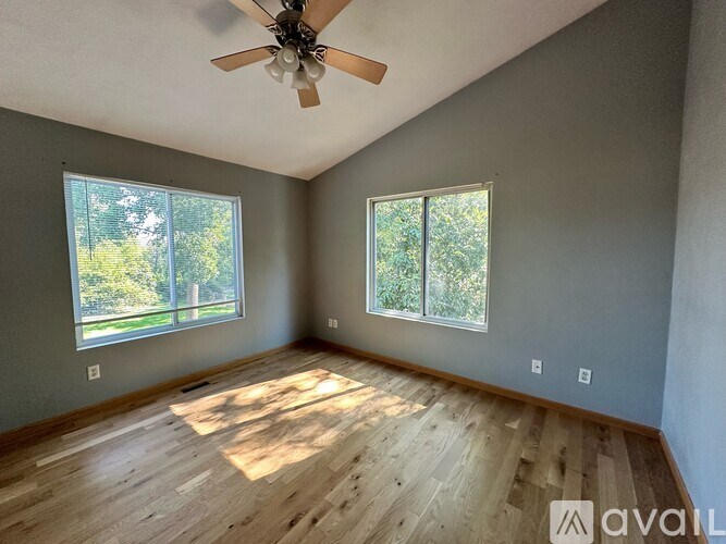 A room with wooden flooring and a ceiling fan.