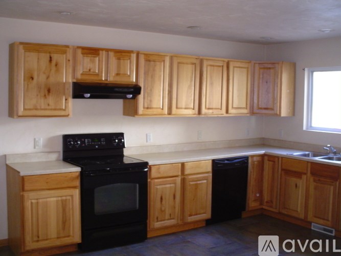 A kitchen with wooden cabinets and black appliances.