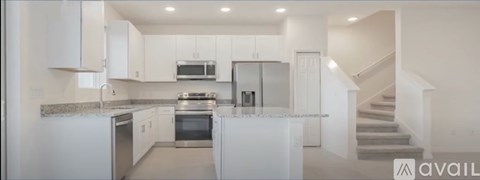 A modern kitchen with white cabinets and stainless steel appliances.