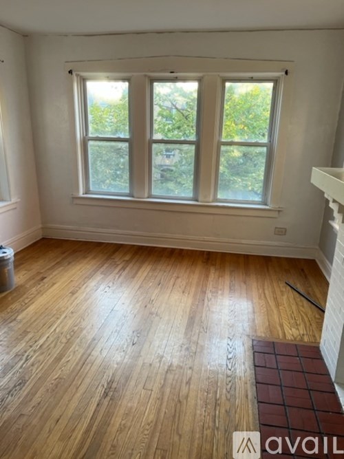A room with wooden floors and a large window.