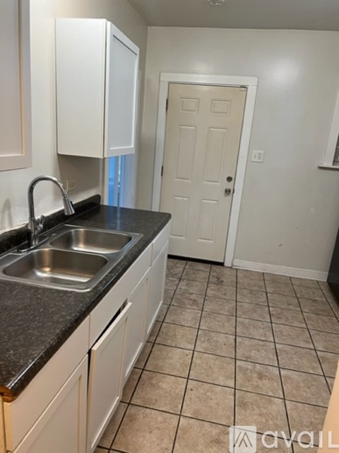 A kitchen with a sink and a door.