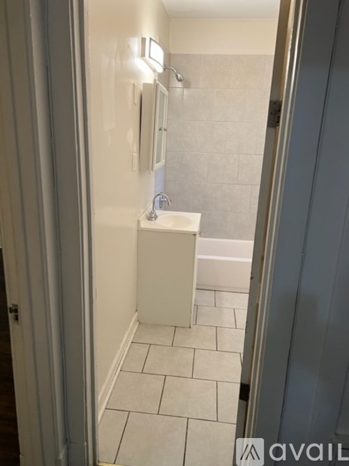 A bathroom with a white sink and tiled floor.