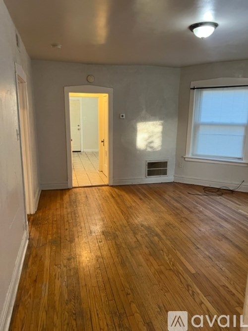 A room with wooden floors and a window.
