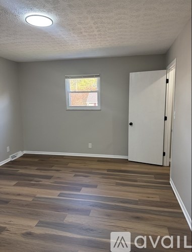 A room with a wooden floor and a white door.