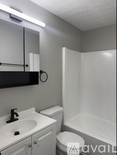 A bathroom with a sink, toilet, and bathtub.
