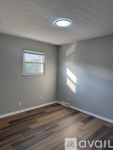 A room with a window and wooden flooring.