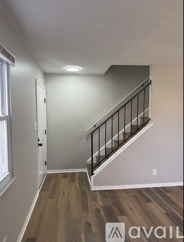 A hallway with a staircase and a window.