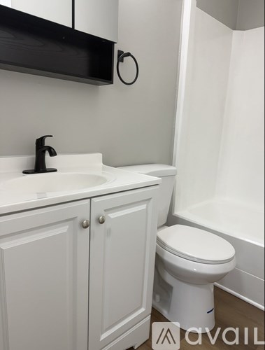A white toilet sits next to a sink in a bathroom.