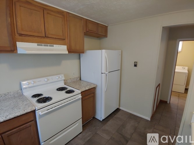 A kitchen with a white stove and refrigerator.