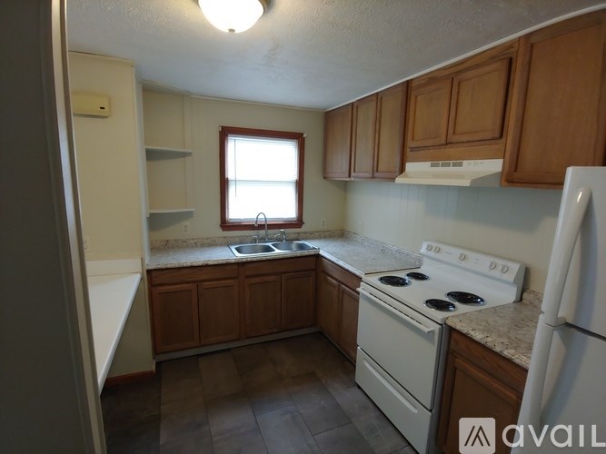 A kitchen with a white stove top oven and white refrigerator.