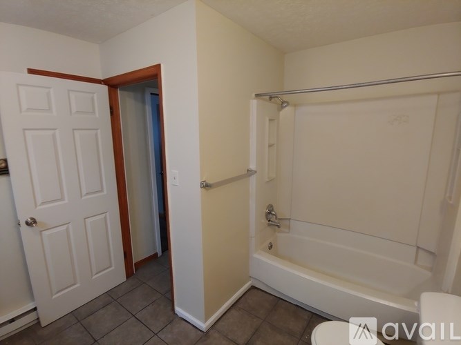 A bathroom with a white tub and a white door.