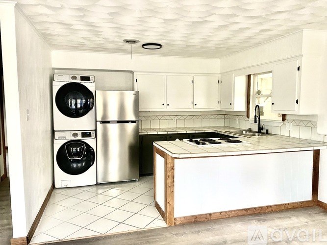 A kitchen with a washer and dryer built into the cabinetry.