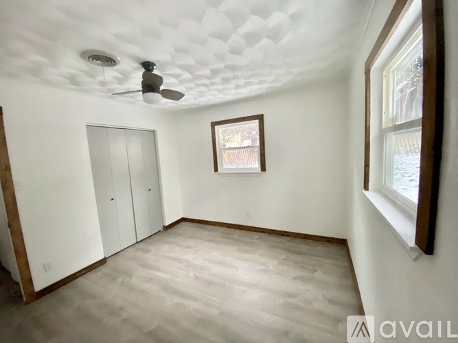 A room with a ceiling fan and a window.
