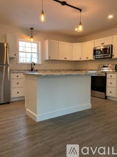A kitchen with white cabinets and a central island.