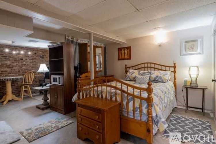 A bedroom with a brick wall and a wooden bed.