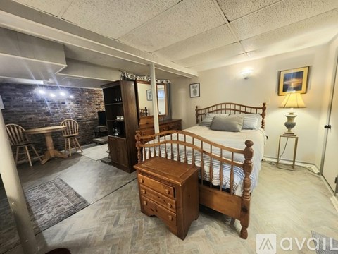 A bedroom with a brick wall and a wooden bed.