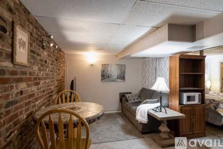 A living room with a brick wall and a round wooden table.