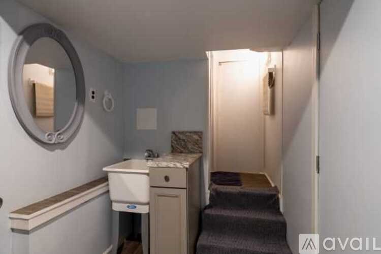 A bathroom with a toilet, sink, and mirror.