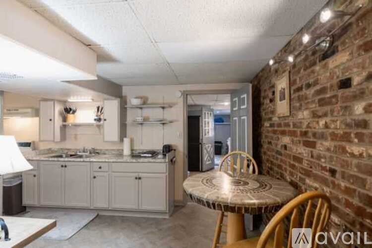A kitchen with a table and chairs in front of a brick wall.