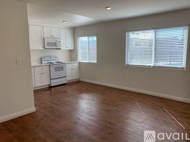 A kitchen with white cabinets and a microwave above the stove.