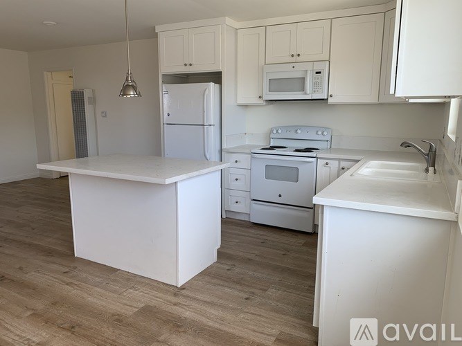 A kitchen with white appliances and cabinets.