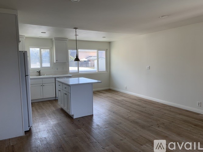 A kitchen with white cabinets and a large island in the middle of the room.