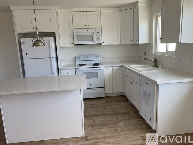 A kitchen with white appliances and cabinets.