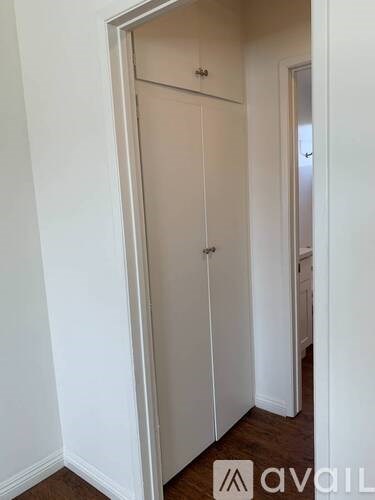 A white door with a handle is in a room with white walls.