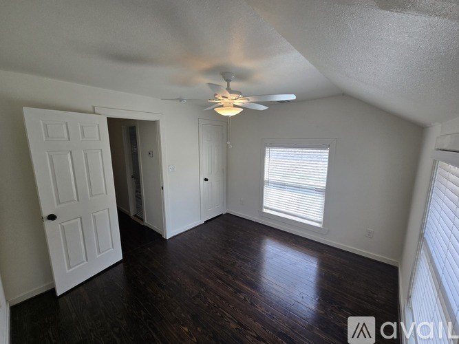 A room with a ceiling fan and a window with blinds.
