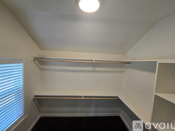 A small, empty room with a window on the left and a shelf on the right.