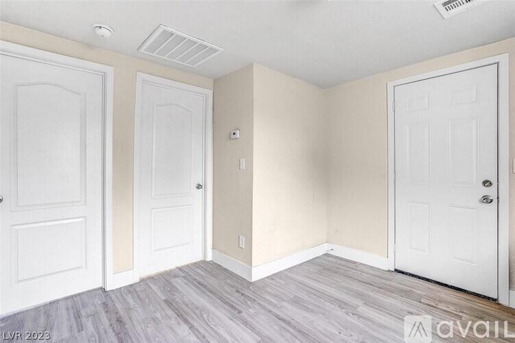 A room with three doors and a wall-mounted light fixture.
