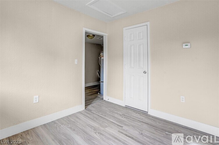 A room with a white door and a light switch on the wall.