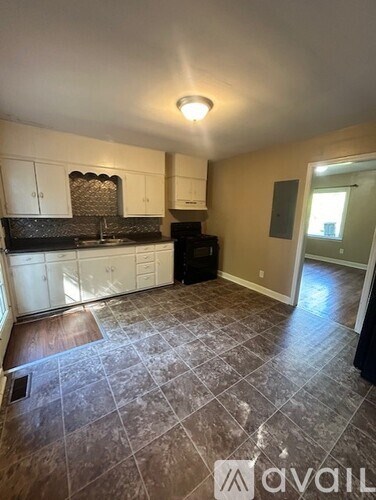 A kitchen with tile flooring and a black oven.