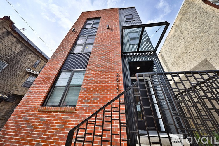 A red brick building with a black metal staircase.
