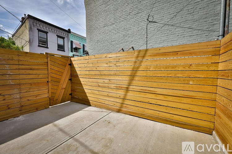 A wooden fence with a concrete ground in front of it.