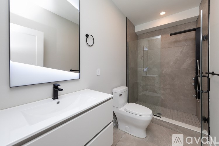 A bathroom with a toilet, sink, and shower.