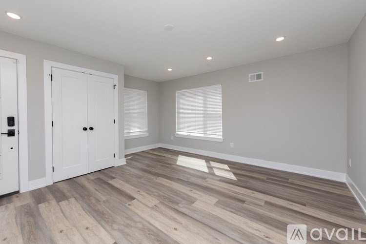 A room with wooden flooring and white walls.