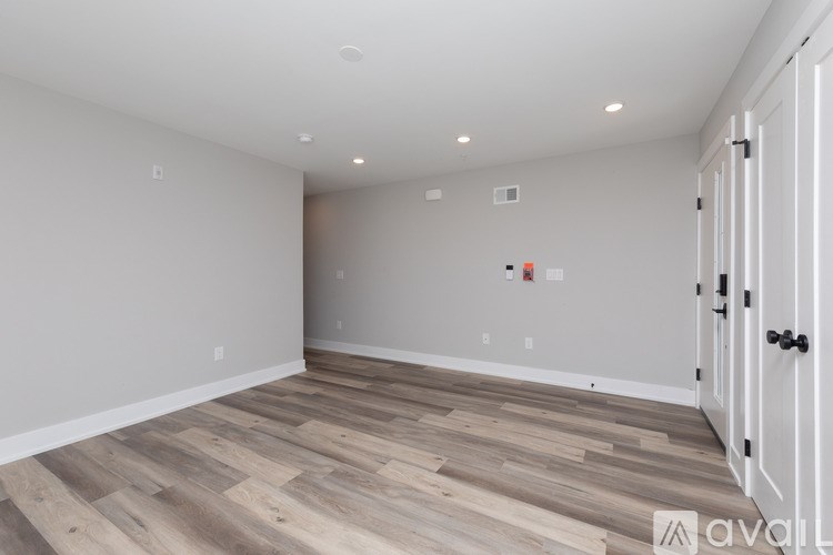 A room with wooden flooring and a white door.