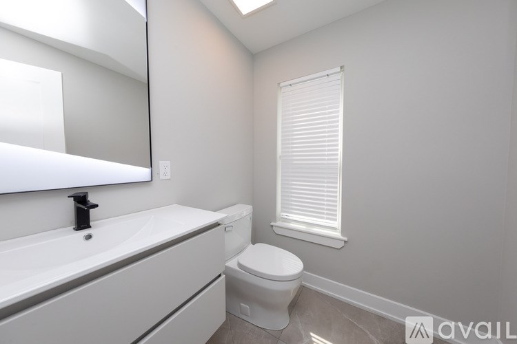 A white toilet sits next to a sink in a bathroom.