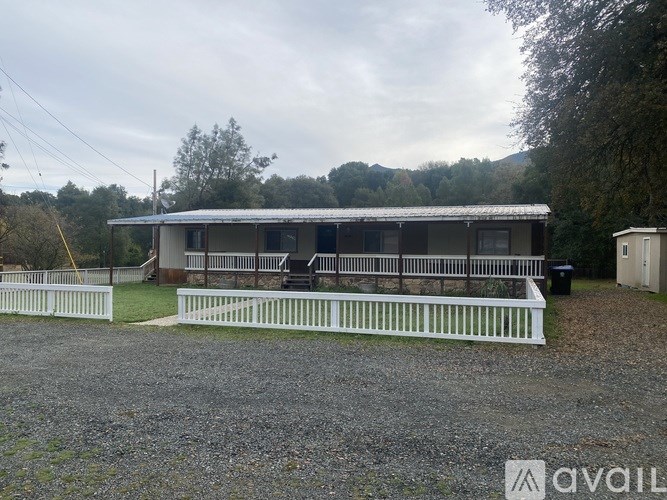 A room with a carpeted floor, a ceiling fan, and a door leading to a hallway.