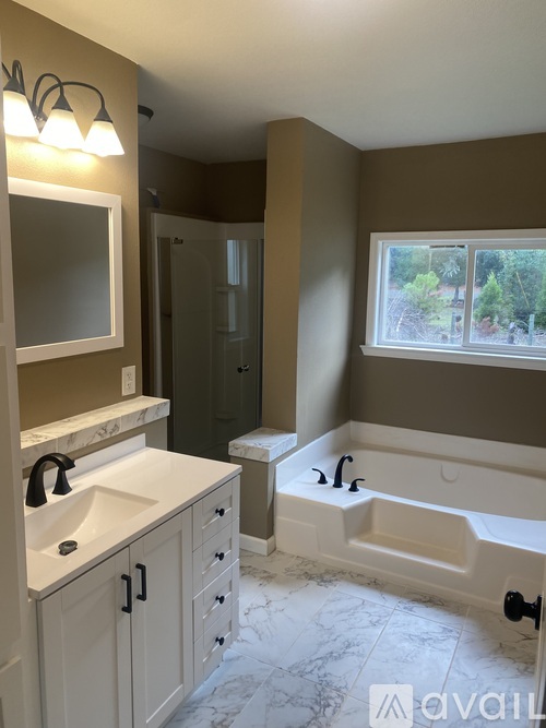 A bathroom with a tub, sink, and mirror.