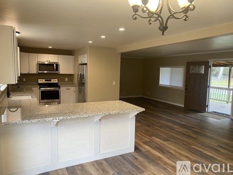 A kitchen with a granite countertop and a chandelier.
