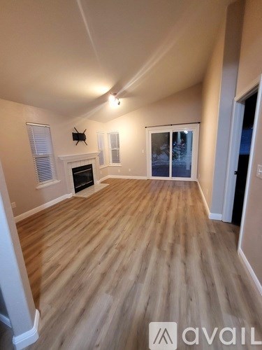 A living room with a fireplace and sliding glass doors.