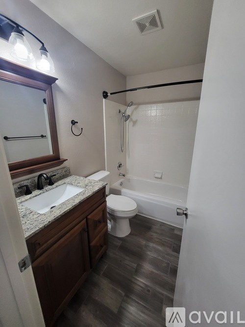 A bathroom with a toilet, sink, and mirror.