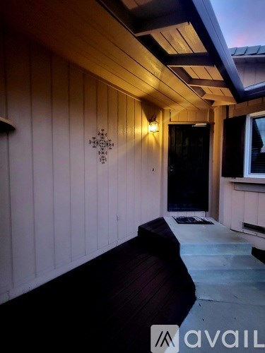 A wooden deck with a bench and a wall decoration.