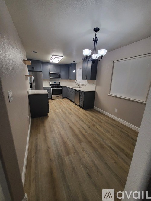 A kitchen with wooden floors and a chandelier.